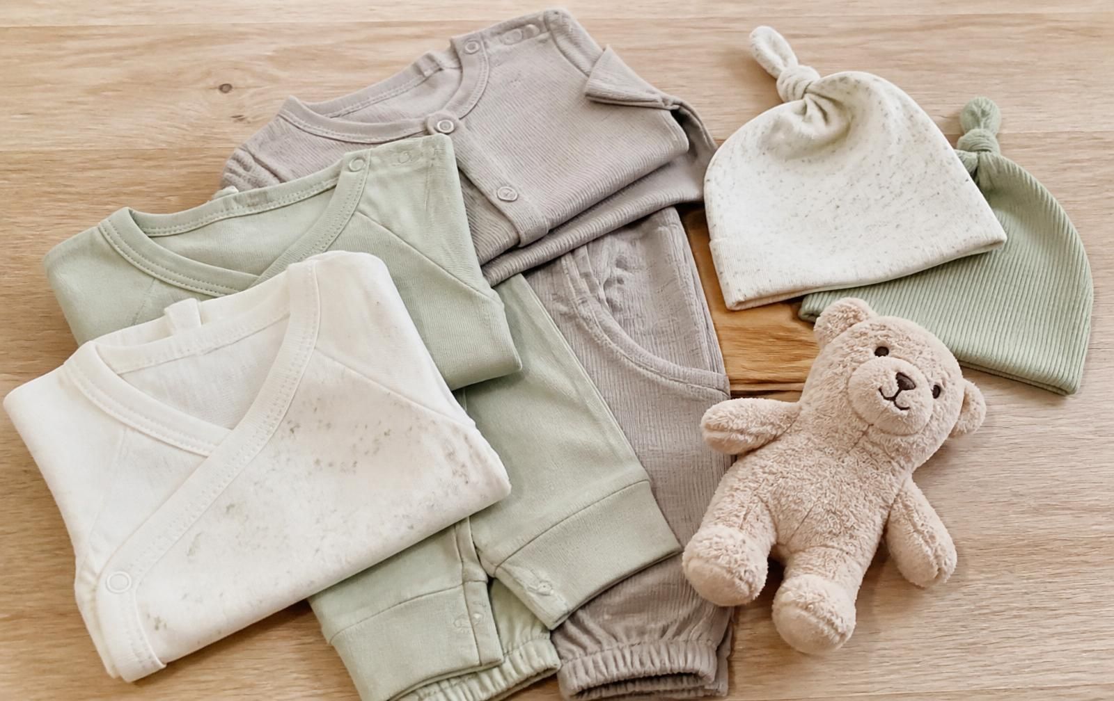 Babykleidung in neutralen Farben als Geschenk zur Geburt